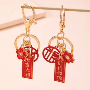 Traditional Chinese gold and red keychain with auspicious charms and blessing words