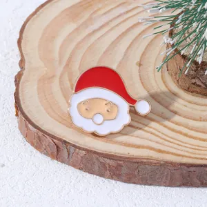 Spilla in smalto Babbo Natale cartone animato su base in legno con aghi di pino innevati