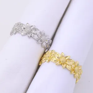 Close-up of silver and gold sunflower napkin rings showing detailed alloy floral patterns