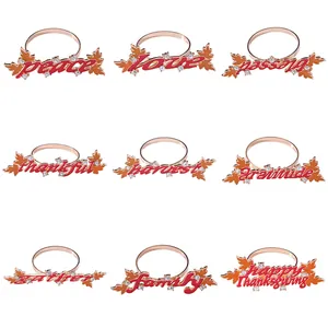 Set of 9 gold Thanksgiving napkin rings with enamel maple leaves and festive words