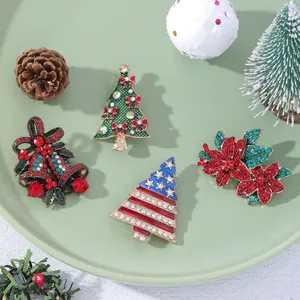 Set of four Christmas brooches featuring Xmas trees, bells, and poinsettia with rhinestones