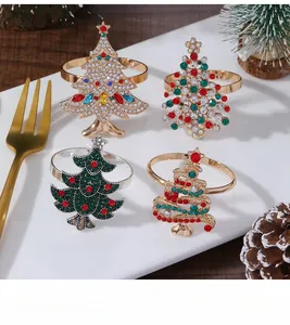 Close-up of four different rhinestone Christmas tree napkin rings on a dinner plate