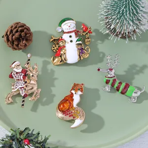 Detail of Christmas brooches with enamel snowman, Santa and reindeer patterns