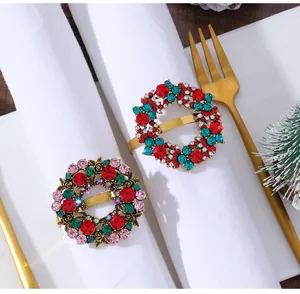 Close-up of golden Christmas wreath napkin rings with colorful rhinestones on a table