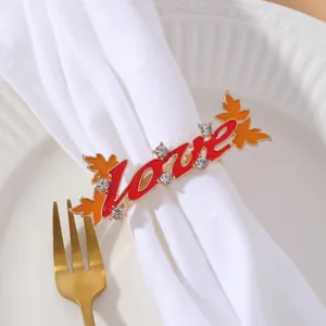 Detail of Love letter napkin ring with maple leaves and rhinestones on a table