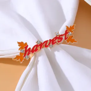 Close-up of golden Harvest napkin ring with red enamel and orange maple leaf detail
