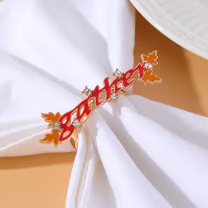 Detail of golden Gather napkin ring with red enamel and autumn maple leaf design