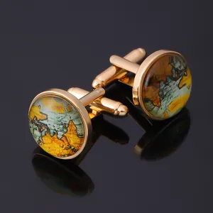 Close-up of gold cufflinks featuring vintage world map patterns and metal clasps