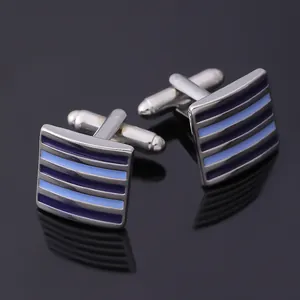 Macro shot of silver-tone cufflinks featuring blue-purple gradient striped enamel details