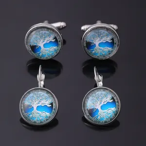 Detailed macro view of silver Celtic tree of life cufflinks and earrings on black background