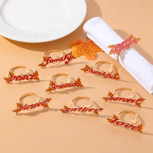 Detail of golden maple leaf napkin rings with engraved gratitude text and rhinestones