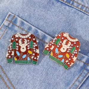 Two Christmas ugly sweater brooches with reindeer and rhinestones on blue denim
