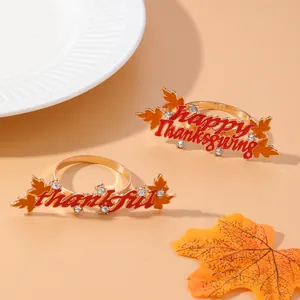 Set of gold Thanksgiving napkin rings with maple leaf designs and holiday text