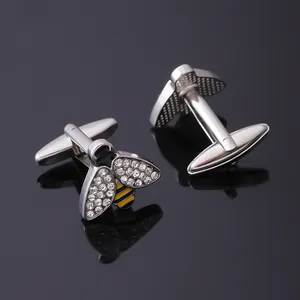 Détail de boutons de manchette abeille avec ailes argentées, strass et émail jaune