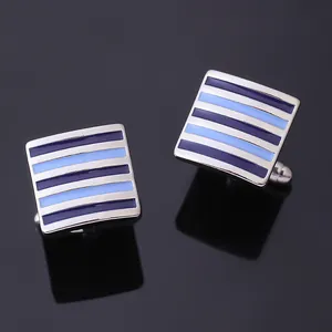 Macro shot of silver square cufflinks featuring blue enamel stripes and bullet back closure