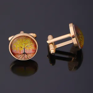 Macro detail of Tree of Life cufflinks featuring golden metal finish and glass dome surface