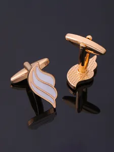 Detailed close-up of gold-plated wing cufflinks with white enamel and T-bar swivel back