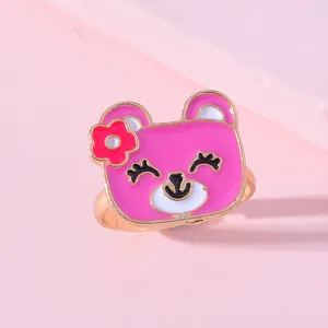 Détail d'une bague pour enfant avec un ours rose mignon et finition en émail coloré