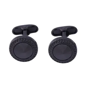 Détail de boutons de manchette ronds noir fusil avec pierre et bordure texturée
