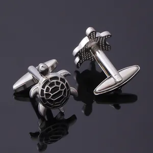 Macro view of silver turtle cufflinks with black enamel shell detail and swivel back