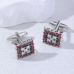 Detail of square vintage cufflinks with black and red enamel inlay and silver relief