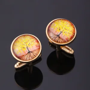 Detailed close-up of golden Tree of Life cufflinks with glass dome on black mirror