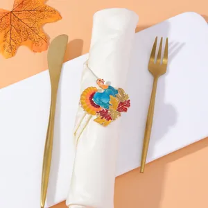Detail of colorful turkey napkin ring with autumn maple leaves on a white linen napkin