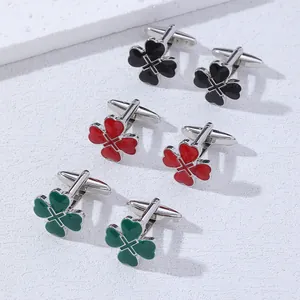 Close-up of three pairs of four-leaf clover cufflinks in black, red, and green enamel
