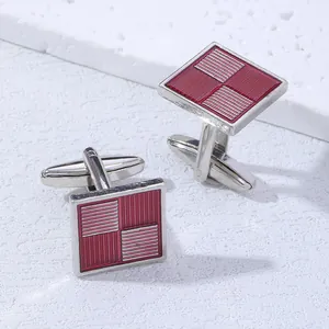 Détail de boutons de manchette carrés argentés avec émail rouge et texture géométrique