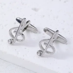 Macro view of silver treble clef cufflinks with polished finish and crystal accent