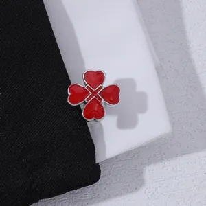 Macro detail of red clover cufflinks featuring heart shaped enamel in silver setting