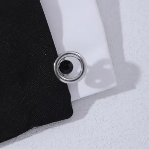 Macro detail of round silver cufflinks with faceted black crystal on fabric edge