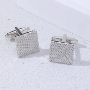 Macro view of square silver cufflinks with textured woven grid pattern for men
