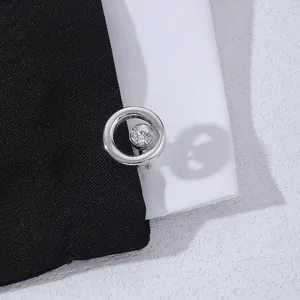 Macro detail of high-grade silver round cufflinks with clear crystal inlay on suit fabric