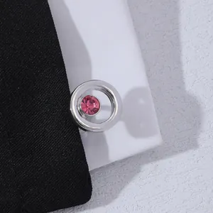 Detailed close-up of round silver cufflinks featuring a faceted pink crystal stone inlay