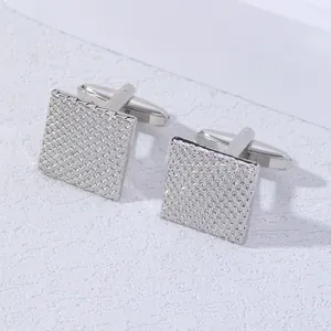 Macro view of square silver cufflinks with textured diamond pattern and bullet back closure
