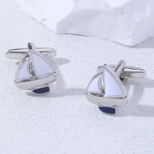 Macro detail of nautical sailboat cufflinks with white and blue enamel on silver metal