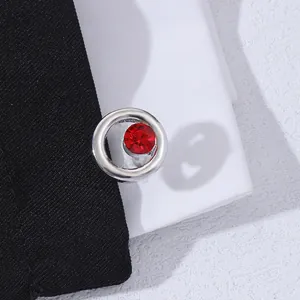 Macro view of silver cufflink with red crystal casting a heart-shaped shadow on shirt