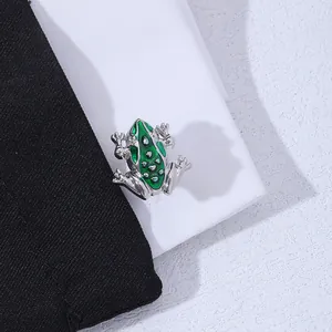 Close-up of green enamel frog cufflinks with silver alloy base and dotted details