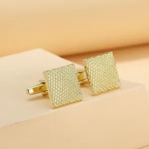 Macro view of square gold cufflinks featuring a refined woven texture and T-bar closure