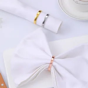 Detailed macro view showing three polished metal napkin rings in gold, silver, and rose gold