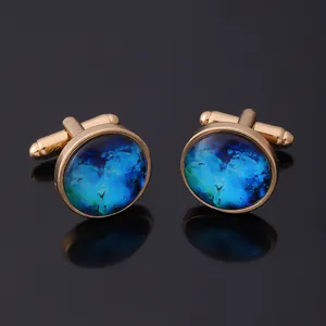 Macro detail of men's gold cufflinks featuring blue starry glass and bullet back closure