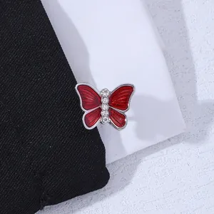 Close-up of red enamel butterfly cufflinks with crystal rhinestones on black fabric