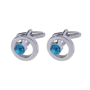 Silver round metal cufflinks with centered blue faceted crystal and T-back closure