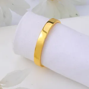 Close-up of elegant polished gold semi-circle napkin ring on a white fabric roll