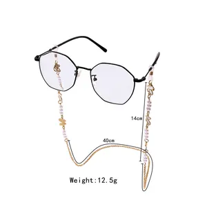 Detail of beaded glasses chain with white pearls and gold butterfly charms for eyewear