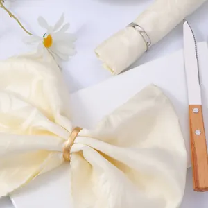 Detalle de los servilleteros dorados y plateados en una mesa elegante y decorada