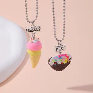 Nahaufnahme der Best Friends Halsketten mit Eiscreme- und Schokoguß-Anhängern auf Rosa