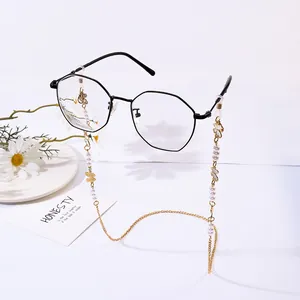 Elegant gold glasses chain with pearls, butterfly charms and black eyewear on white background