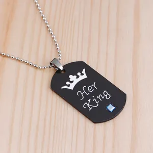 Close-up of black dog tag pendant with crown motif, Her King engraving, and blue stone